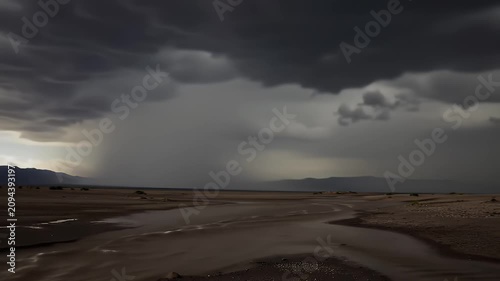 Overcast Sky with Gathering Storm over a Desert Landscape with a Winding River