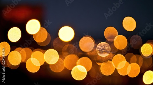 Soft golden orbs of light shimmer against a dark, blurred background