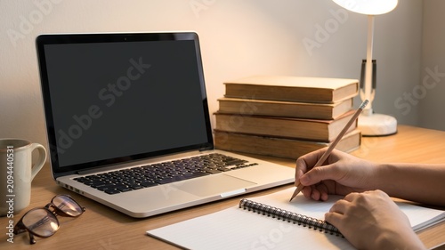 Online Learning Workspace with Laptop, Books and Hand Writing Notes