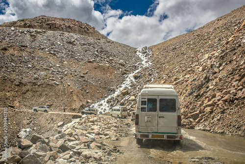 Photography Vehicles crossing a water ford on a mountain dirt road in Ladakh