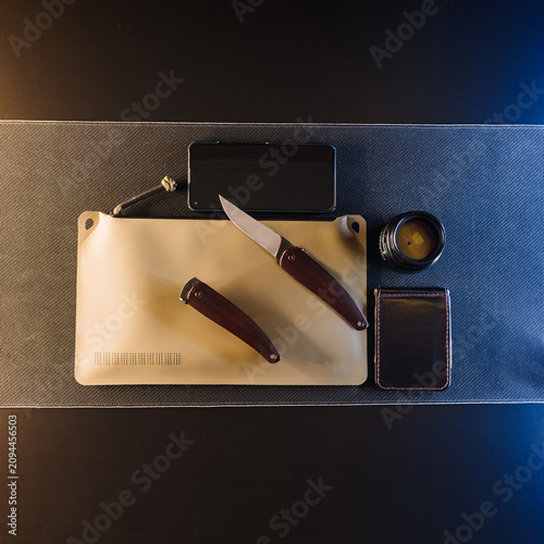 Tactical EDC gear flat lay with pocket knives and dry bag under cinematic teal and orange lighting.