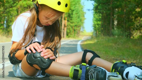 Knee injury and a girl on roller skates sitting on the floor outside. Sports, emergency medical care and a hurt leg after fall.