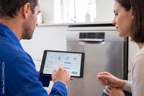 Repair expert demonstrating smart kitchen appliance settings