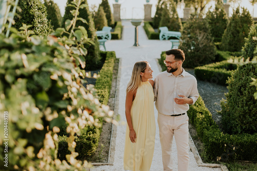 Couple enjoying a peaceful stroll through a beautiful garden at sunset
