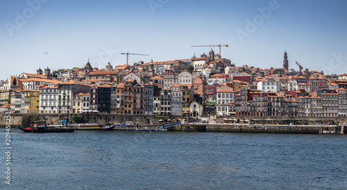 Foto Vista panorámica horizontal de la Ribeira de Oporto, Portugal, con sus coloridos edificios tradicionales a la orilla del río Duero, barcos amarrados y la Torre de los Clérigos al fondo