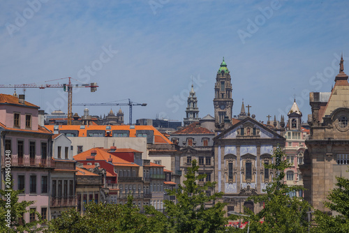 Foto Vista urbana de Oporto con la fachada de azulejos de la iglesia de los Congregados, la Torre de los Clérigos al fondo, tejados tradicionales y grúas de construcción