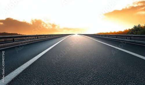 empty open highway stretching to a bright sunrise horizon with asphalt lanes, metal guardrails and trees under a golden cloudy sky, evoking hope and freedom
