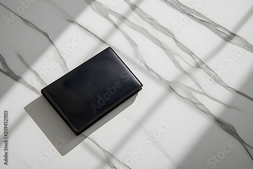 A minimalist passport travel wallet displayed on smooth white marble with soft studio lighting and elegant shadows.