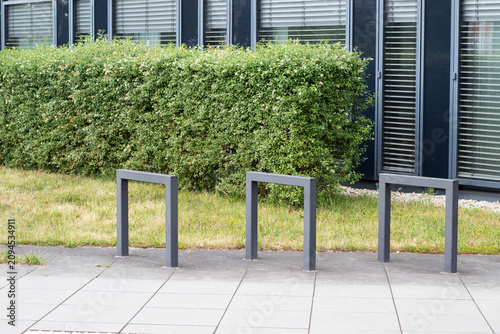Canvastavla Modern urban landscape featuring three gray metal bike racks positioned on a pav