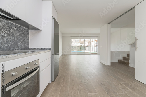 Quadro su tela Contemporary minimalist kitchen featuring sleek white handleless cabinetry, dark