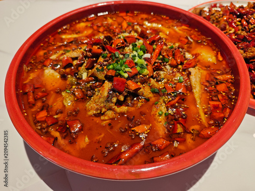  red bowl of Sichuan boiled pork slices features tender meat in a fiery, numbing chili oil sauce