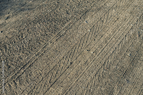 фотографія Tire tracks impressed into dry dirt ground