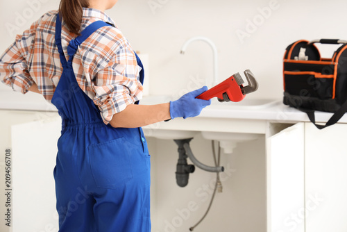 Female plumber in blue over...