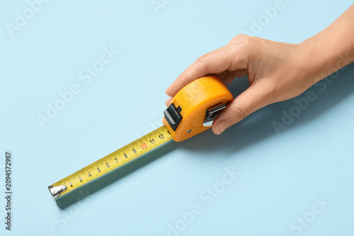 Hand holding a yellow measu...