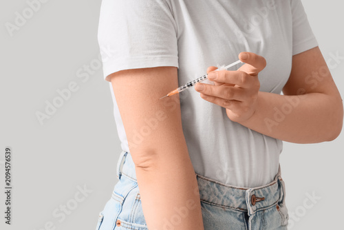 Woman self-injecting medica...