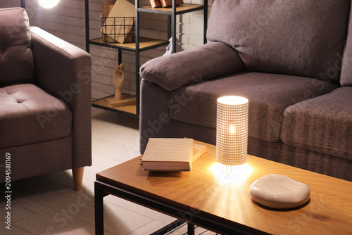 Glowing lamp with books on ...