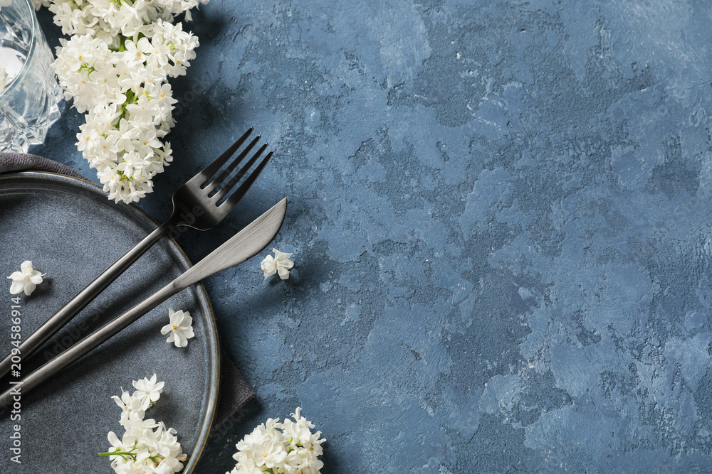 Obraz premium Beautiful table setting with white lilac flowers on blue background