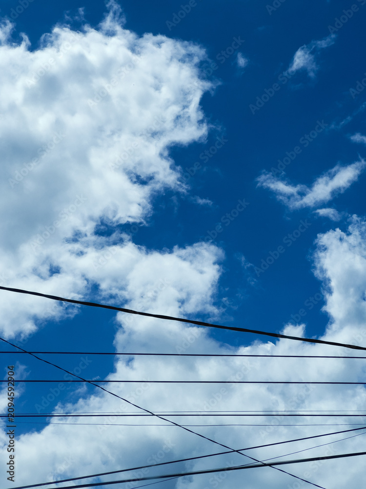 Fototapeta premium Clear Blue Sky With White Clouds and Wires