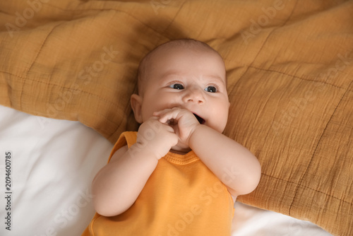 Cute baby lying on bed, clo...