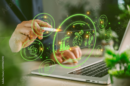 Foto Business hand using stylus on laptop with green holographic CO2 dashboard, climate data, renewable energy icons, carbon reduction, sustainability technology and eco innovation concept