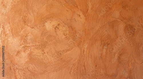 Warm terracotta clay plaster texture background with organic troweled finish