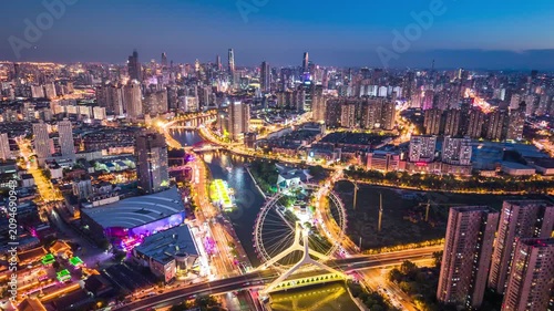 Aerial night timelpase of the Tianjin Eye Ferris wheel over the Haihe River in Tianjin, China