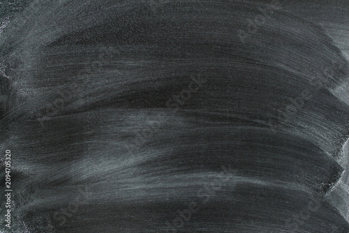 Dark chalkboard texture with dust and scratches. Messy chalk dust and smudges, grunge background with empty space for text.
