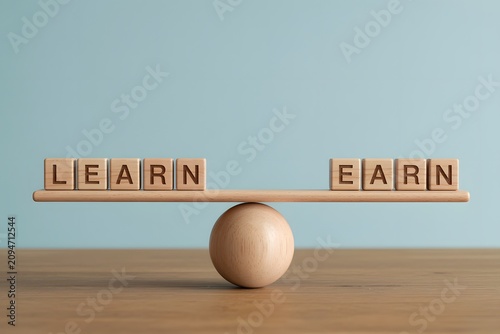 Balancing Learn and Earn wooden blocks on a seesaw conceptualizing education investment and financial returns