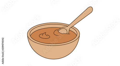 A wooden spoon rests in a bowl filled with smooth, brown peanut butter