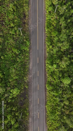 Motorcyclist riding on a forest road viewed from above
