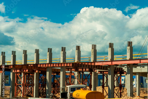 Construction site shows building structure under development with clouds in the sky