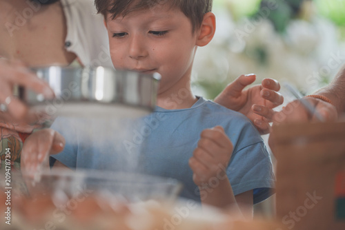 Foto A mum and her curious son learn to bake step by step in a sunlit home kitchen, celebrating home life and family connection, a cosy lifestyle moment of love and belonging