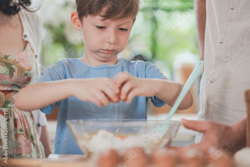 Bild auf Leinwand A mum and her curious son learn to bake step by step in a cosy family kitchen, a tender everyday moment of togetherness, on a bright day, with tenderness, at home