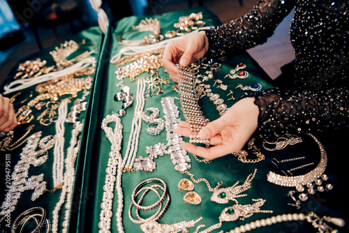 Obraz na plátně Woman examining a sparkling bracelet on a jewelry display at a boutique market t