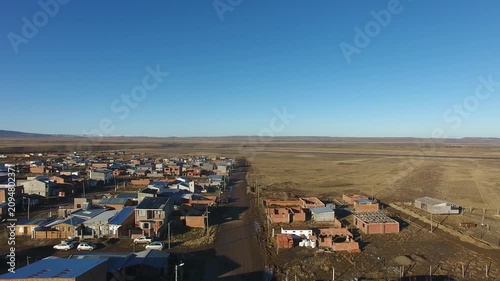 4K aerial drone footage flying over 28 de Noviembre, a Patagonian town in Santa Cruz, Argentina. Scenic mountain surroundings, residential neighborhoods, and the unique landscape of southern Patagonia