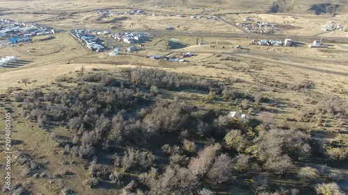 4K aerial drone footage flying over 28 de Noviembre, a Patagonian town in Santa Cruz, Argentina. Scenic mountain surroundings, residential neighborhoods, and the unique landscape of southern Patagonia