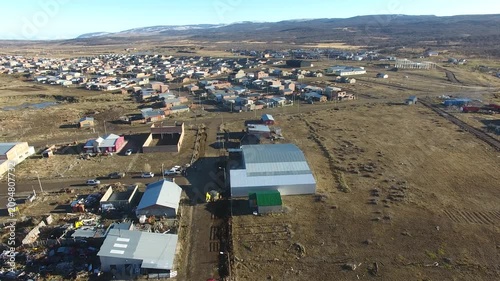 4K aerial drone footage flying over 28 de Noviembre, a Patagonian town in Santa Cruz, Argentina. Scenic mountain surroundings, residential neighborhoods, and the unique landscape of southern Patagonia