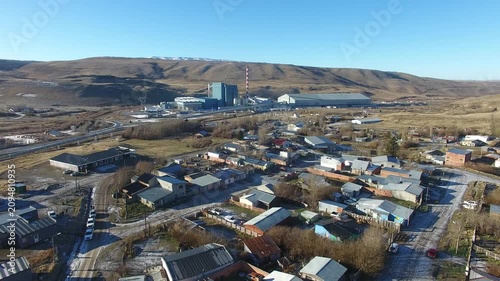 4K aerial drone footage flying over Julia Dufour, a Patagonian megausina in Santa Cruz, Argentina. Scenic urban landscape surrounded by rugged mountains, showcasing the beauty of southern Patagonia.