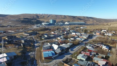 4K aerial drone footage flying over Julia Dufour, a Patagonian megausina in Santa Cruz, Argentina. Scenic urban landscape surrounded by rugged mountains, showcasing the beauty of southern Patagonia.