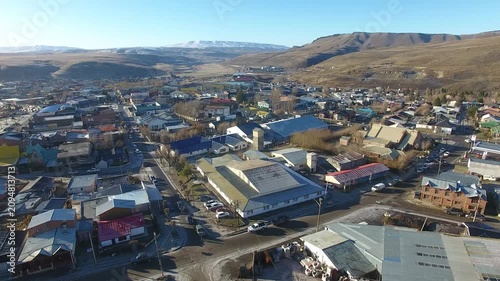 4K aerial drone footage flying over Río Turbio, a Patagonian mining town in Santa Cruz, Argentina. Scenic urban landscape surrounded by rugged mountains, showcasing the beauty of southern Patagonia.