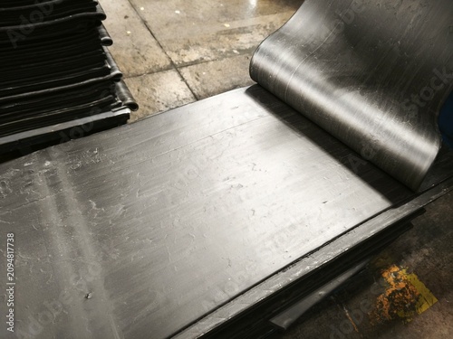 Industrial raw rubber compound sheets stacked in a production plant
