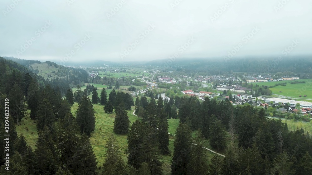 Fototapeta premium Aerial view observing the mountain village at sunrise fog