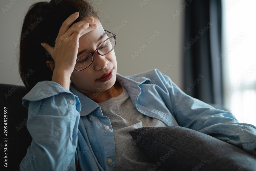 Fototapeta premium Young Asian Woman Suffering from Headache and Mental Stress After Excessive Smartphone Use at Home, Digital Burnout, Screen Fatigue, Work From Home Lifestyle and Health Awareness