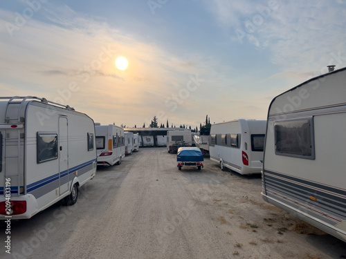 Caravans stored in outdoor storage lot at sunset