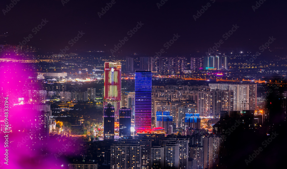 Fototapeta premium Urban skyline illuminated with colorful lights at night Sanya, Hainan Island, China