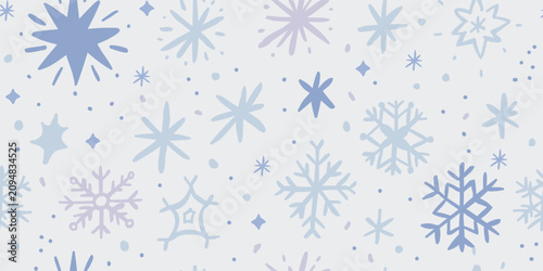 Seamless winter pattern with pastel snowflakes, stars and falling snow on a soft gray background. Cute Christmas blizzard design for kids, fabric, wallpaper, wrapping paper and seasonal holiday decor