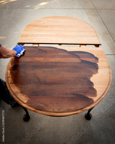 Master craftsman applies stain to a tabletop