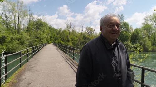 Smiling elderly man with grey hair walking on a bridge promoting healthy ageing and mental health in older adults