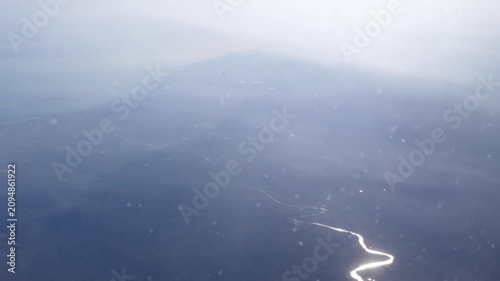 Winding river sparkling in the sun from above showcasing aerial natural landscapes