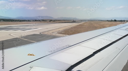 View from an airplane window during takeoff preparation at the airport runway